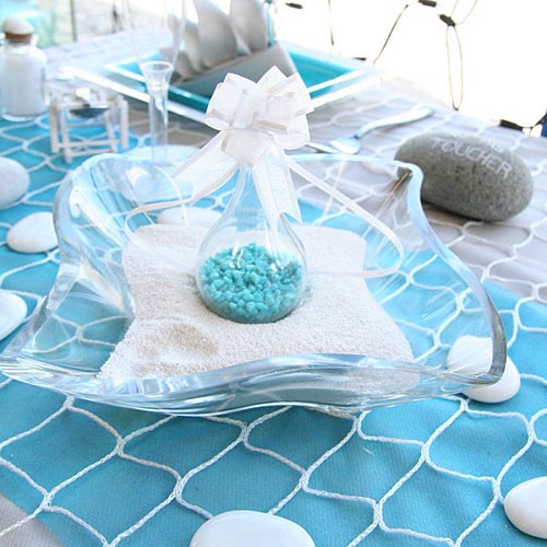 table cloth in turquoise color and beach stones for table decoration