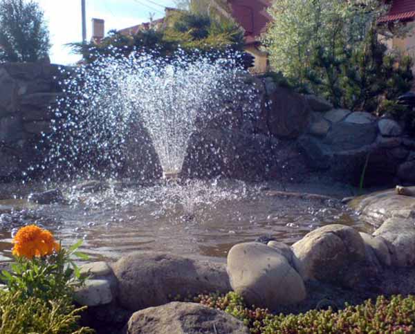 outdoor fountain with a border of natural stone is one of the simple backyard landscaping ideas