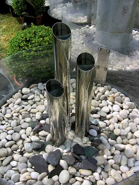 small water fountain design ideas with beach pebbles and metal pipes for contemporary garden designs