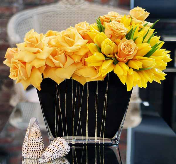 yellow roses and shells create unique table centerpiece