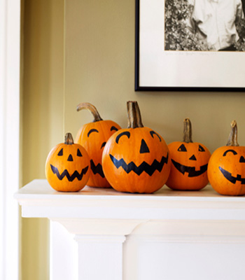 fireplace decorate with smiling pumpkins display black and orange color combination