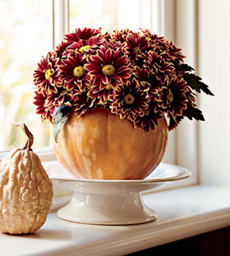 purple mums in large pumpkin vase