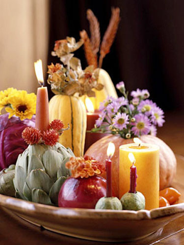 table centerpiece with pumpkin vases and flowers arranged on tray with yellow candles