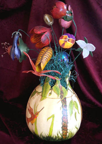 painted birds on pumpkin vase with artificial flowers for table decoration