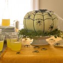 green pumpkin centerpiece with black spiders for Halloween party table decoration
