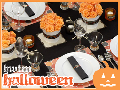 orange roses in white vases and black tablecloth for halloween decorating