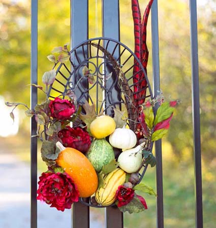 wreath made of colorful pumpkins and gourds with red flowers