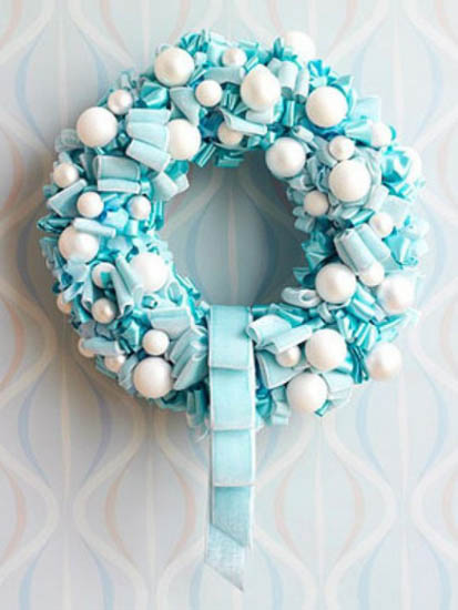 makes Christmas wreath of white and blue balls and ribbons