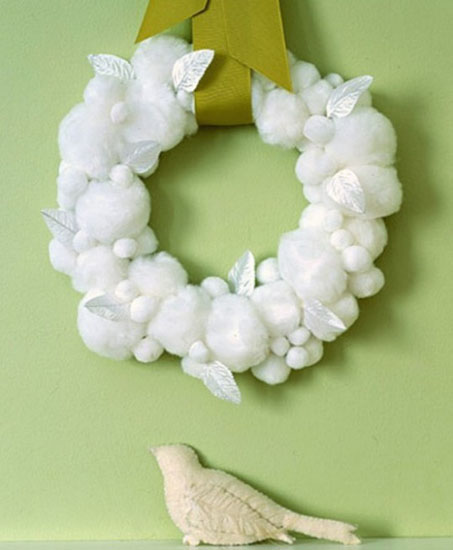 making christmas areath of white balls and leaves