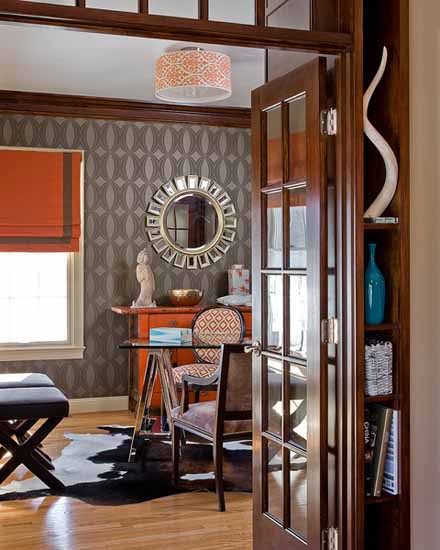 black and white wallpaper with orange furniture and curtain