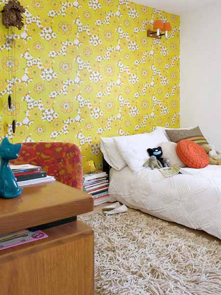 orange cushion and light green wallpaper in bedroom