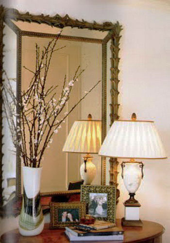 flowering branches in white vase and table lamp