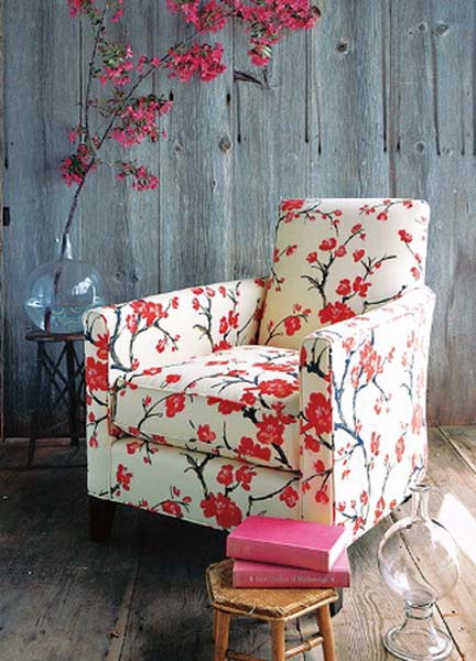 flowering branches with pink flowers and chair with floral upholstery fabric in white and pink colors