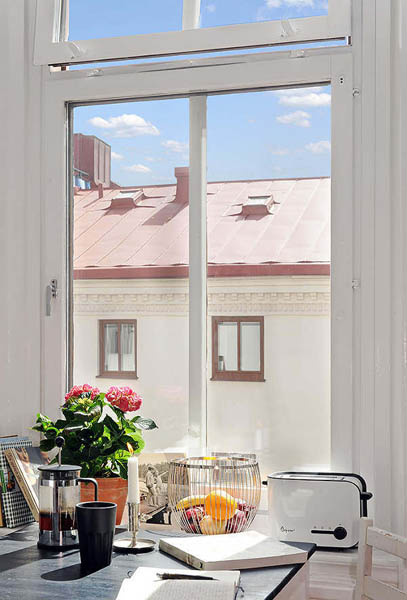 kitchen window with pinkish red flowers