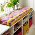 white bench with storage and colorful cushions