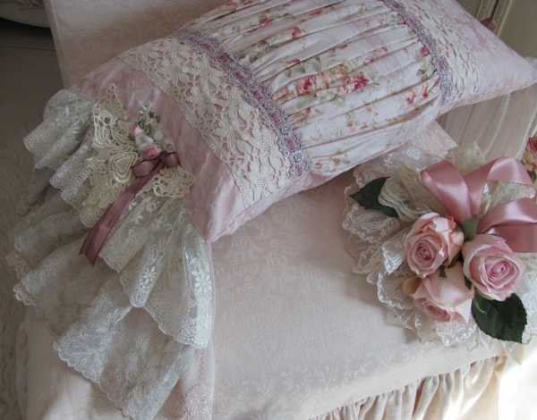 handmade pillow with roses made of lace fabric and ribbons in white and pink colors