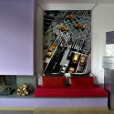 Living room design with inglenook fireplace, steel sculpture, red sofa and large work of art