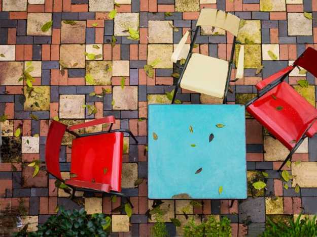  outdoor furniture in blue and red color on a brick patio 