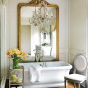 golden large wall mirror and white sink with yellow flowers in the modern bathroom