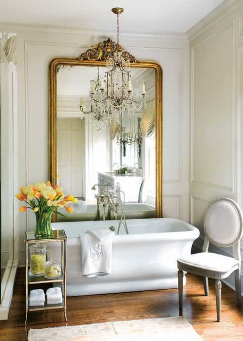 golden large wall mirror and white sink with yellow flowers in the modern bathroom