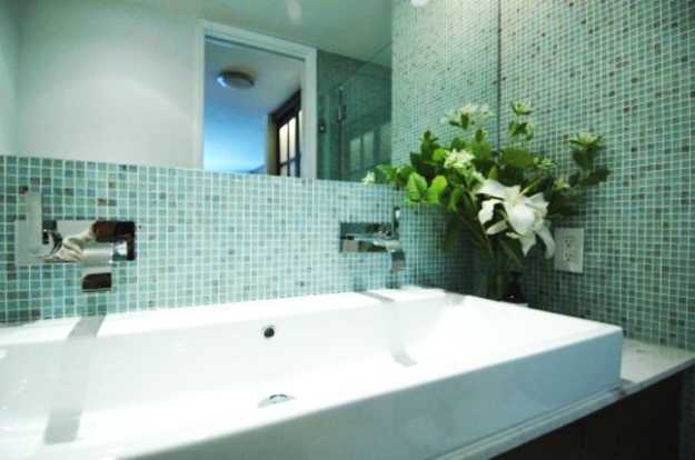 green bathroom mosaic tiles and white flowers