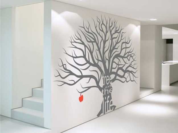 gray tree with red apple on a white wall