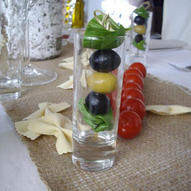 red tomatoes and olives in jars for the table decoration Italian