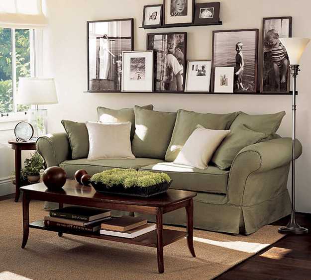 living room sofa in green paint and wall decoration with black and white photos