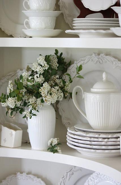 white flowers and white crockery set on the shelves